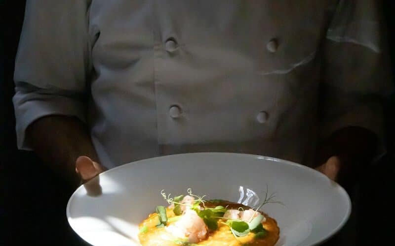 Chef à domicile présentant une assiette dressée