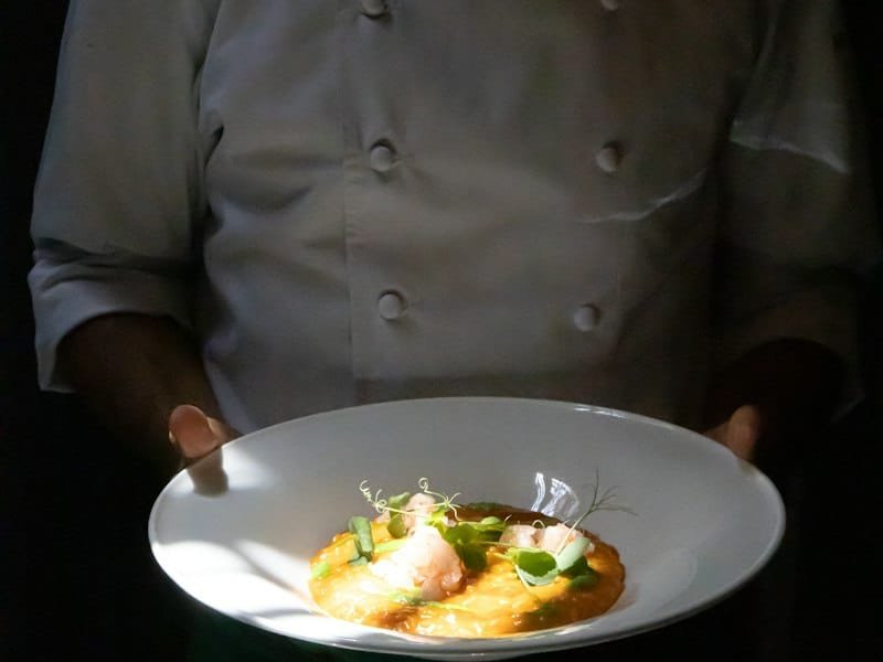 Chef à domicile présentant une assiette dressée