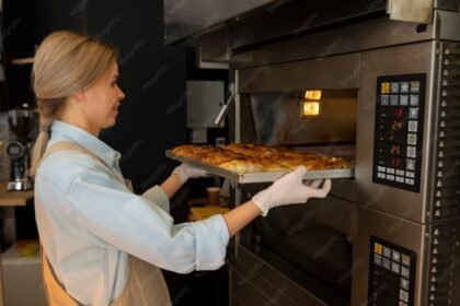Boulangère au travail devant un four professionnel